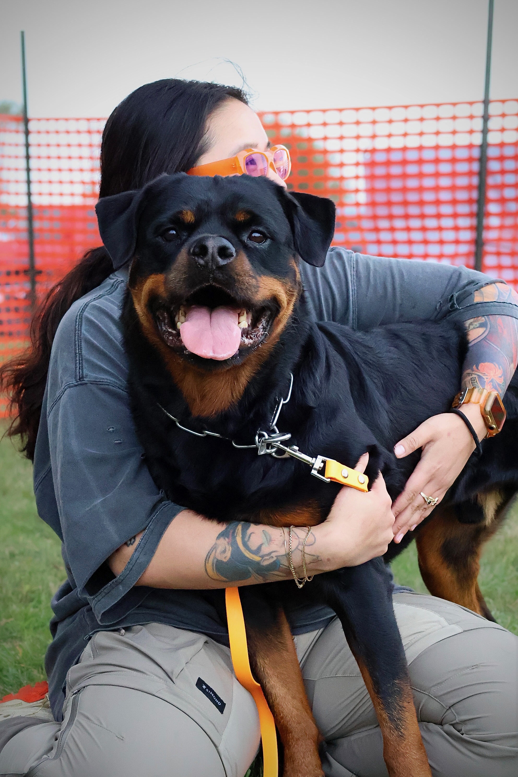 Kneeling trainer hugging their smiling dog